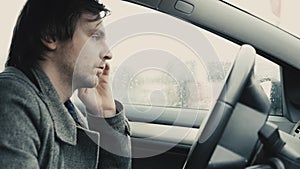 Man use mobile phone, abstract of cars in the rain as background.