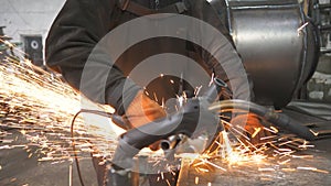 Man use saw cutting machine to cut metal. Craftsman with circular saw sawing steel in garage. Industrial professional