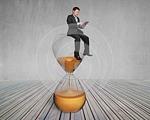 Man use smart pad sit on sandglass