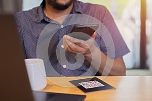 Man use smartphone to scan QR code for choose menu and order menu in cafe restaurant with a digital delivery