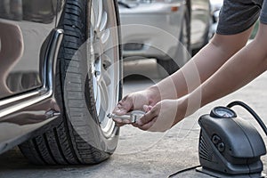 man use Tire gauge analog check air pressure of wheel car on the road basic maintenance by oneself