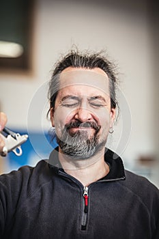 A man uses an air gun to blow his beard up