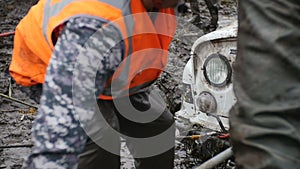 Man uses big hoisting jack to lift off-road vehicle in slow motion. Try to get stucked car from mud and dirt.