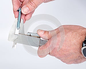 Man uses a caliper to measure the diameter of a screw