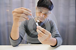 Man uses cotton swab to test for Covid-19 Insert a reagent bottle to look for what is believed to be a virus