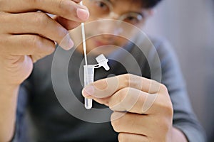 Man uses cotton swab to test for Covid-19 Insert a reagent bottle to look for what is believed to be a virus