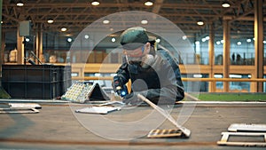 A man uses drill while preparing discarded garbage for recycling.