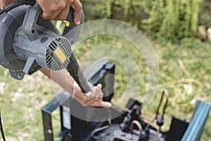 A man uses an electric air blower to dry a cleaned and washed window type air conditioning unit outside. Aircon cleaning service