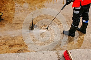 A man uses an electric pressure washer for a pressure washer. Cleaning city fountains in autumn. Workers remove the dirt that has