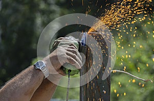 Man uses flexible that makes sparks without using protective gloves. Lack of use of protection systems