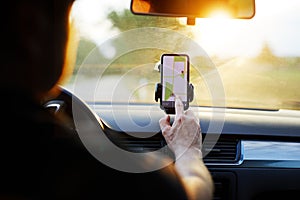 Man uses navigation on his mobile phone in the car