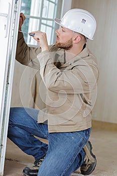 Man uses screwdriver to adjust glass door