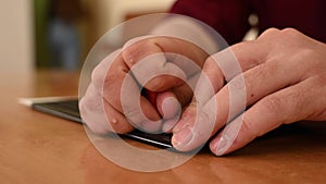 A man uses a special stencil and stylus to write a letter in braille.