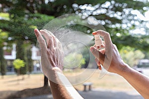 Man uses a spray of alcohol to get rid of bacteria and viruses