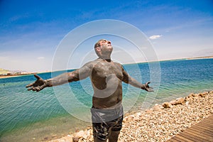 Man uses therapeutic mud, enjoying the sun photo