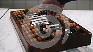 Man uses vintage old wooden abacus. Media. Close up of male hand counting with a USSR soviet old fashioned calculating
