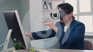 Man uses Virtual Realitiy glasses and computer. VR headset in work concept