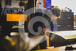 Man using an angle grinder on a car door