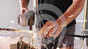 Man using angle grinder for cutting metal profile