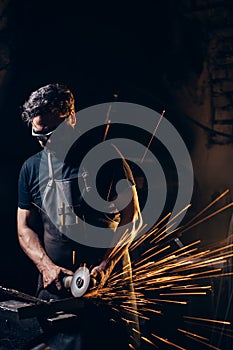 Man Using Angle Grinder in Factory and throwing sparks