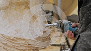 Man using angle grinder with holes cutter saw for carving wood - close up