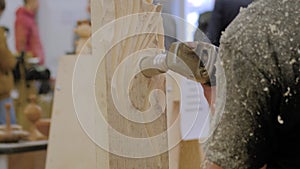 Man using angle grinder with holes cutter saw for carving wood - close up