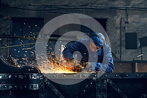 Man using angle grinder for polishing metal construction