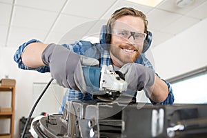 Man using angle grinder in workshop