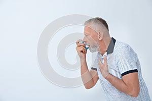 Man using asthma inhaler