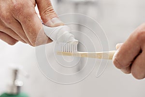 Man using a bamboo toothbrush in the bathroom