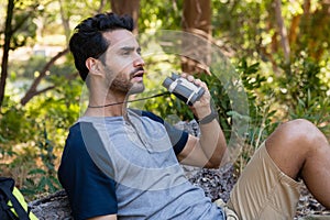 Man using binoculars while resting in the forest