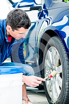 Man using brush for cleaning the surface of the rim