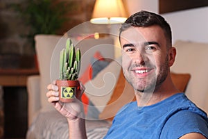 Man using a cactus to absorb radiation at home