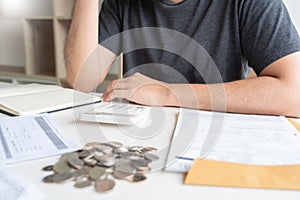 Man using calculator and calculate bills receipt in home expenses payments costs with paper note, financial account management and