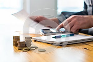 Man using calculator and reading financial document paper.