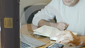 Man using calculator and sorting money into jars for retirement and emergency fund. Budgeting concept