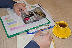 The Man are using a calculator on the table in the office room. accounting and business concept