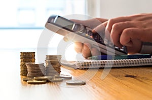 Man using calculator to count money savings and living costs.