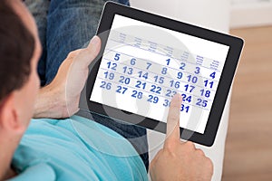Man using calendar on digital tablet