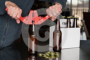 Man using capper to put metal caps on beer bottle
