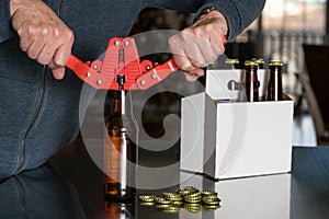 Man using capper to put metal caps on beer bottle