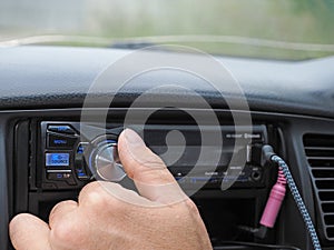 Man using car audio stereo magnet.