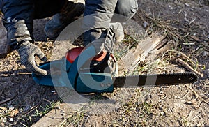 A man is using a chainsaw to cut a log