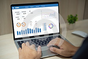 Man using computer laptop software with graphs and charts showing sales data. CRM Customer Relationship Management. Business
