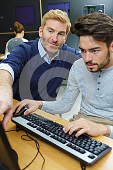 man using computer with teacher guidance