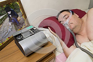 Man using CPAP Machine and Sleeping Mask for Treatment of Sleep