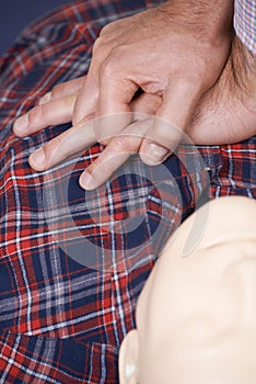 Man Using CPR Technique On Dummy In First Aid Class