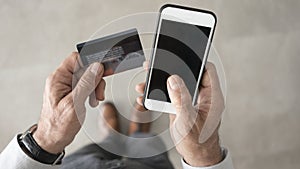 Man using credit card and mobile phone