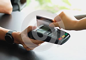 Man using credit card swipe machine for sell products in the shop to customers. Concept of spending via credit card