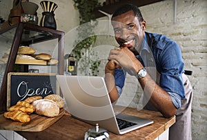 Man using devices for online business order at bakehouse photo